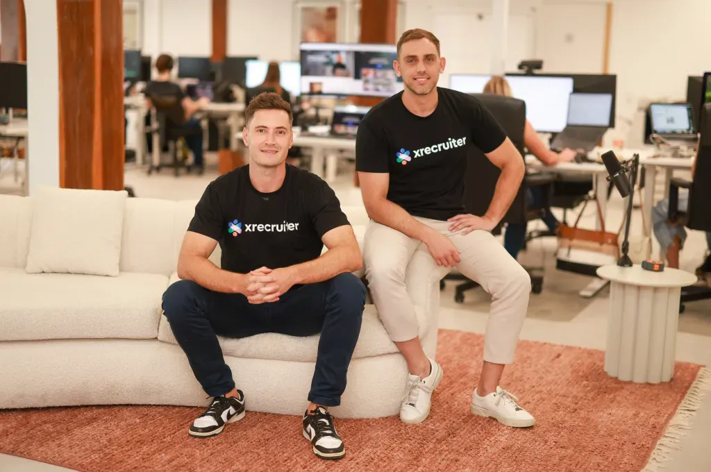 xrecruiter founders wearing branded t-shirts at their office. Featured in Forbes Australia. Recruitment platform identity by WeGrow